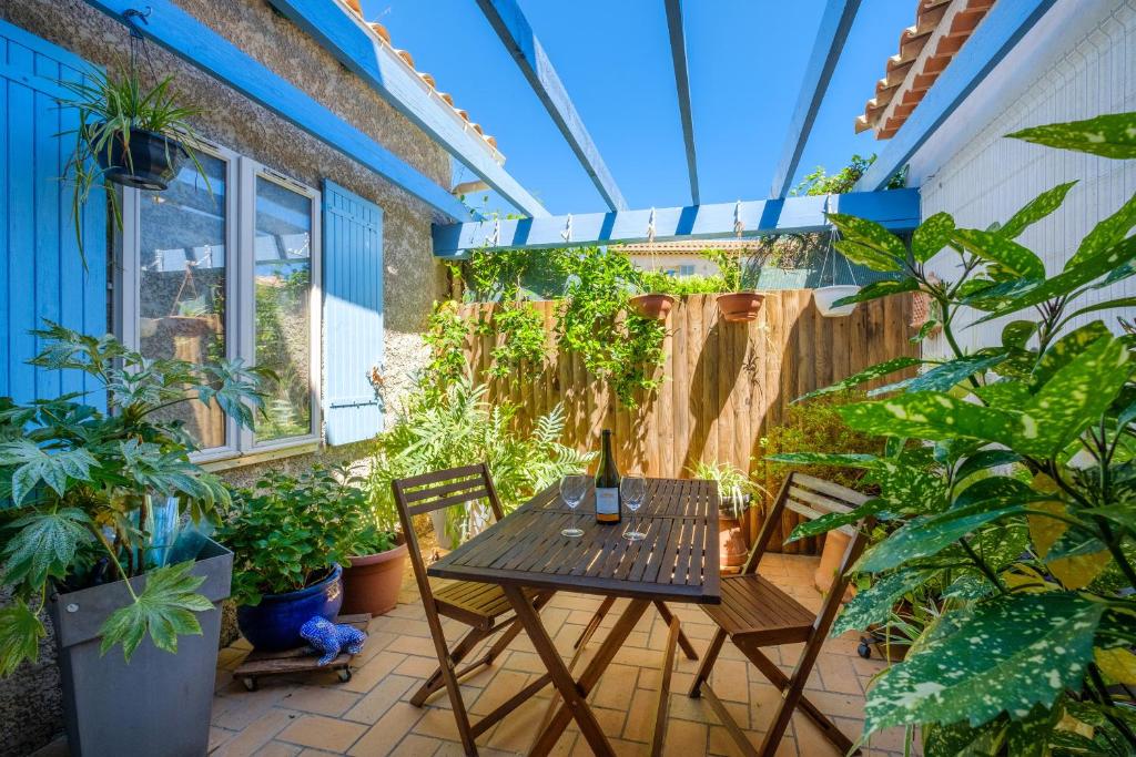 un patio avec une table, des chaises et des plantes dans l'établissement Villa 3 chambres - jardin privé, à Tourrettes-sur-Loup
