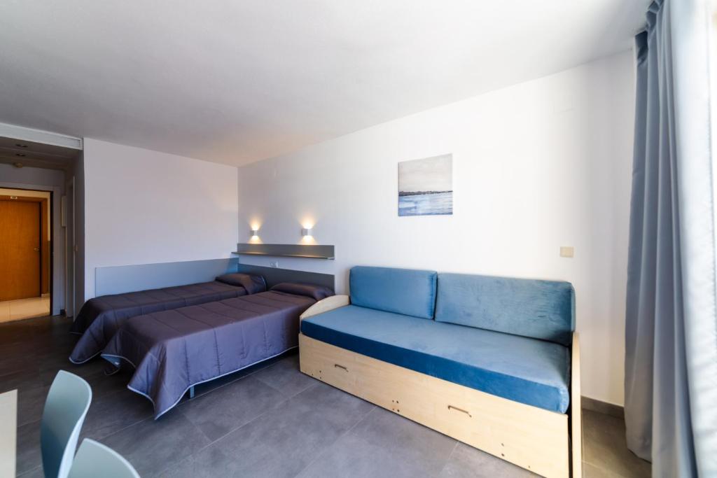 - une chambre avec un lit et un canapé bleu dans l'établissement Inter 2, à Salou