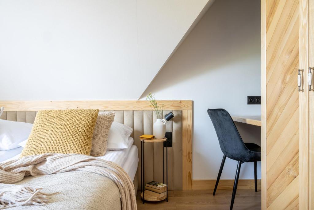 a bedroom with a bed and a desk and a chair at Aparteo Domek na 102 - Jeleń i Loft in Kościelisko