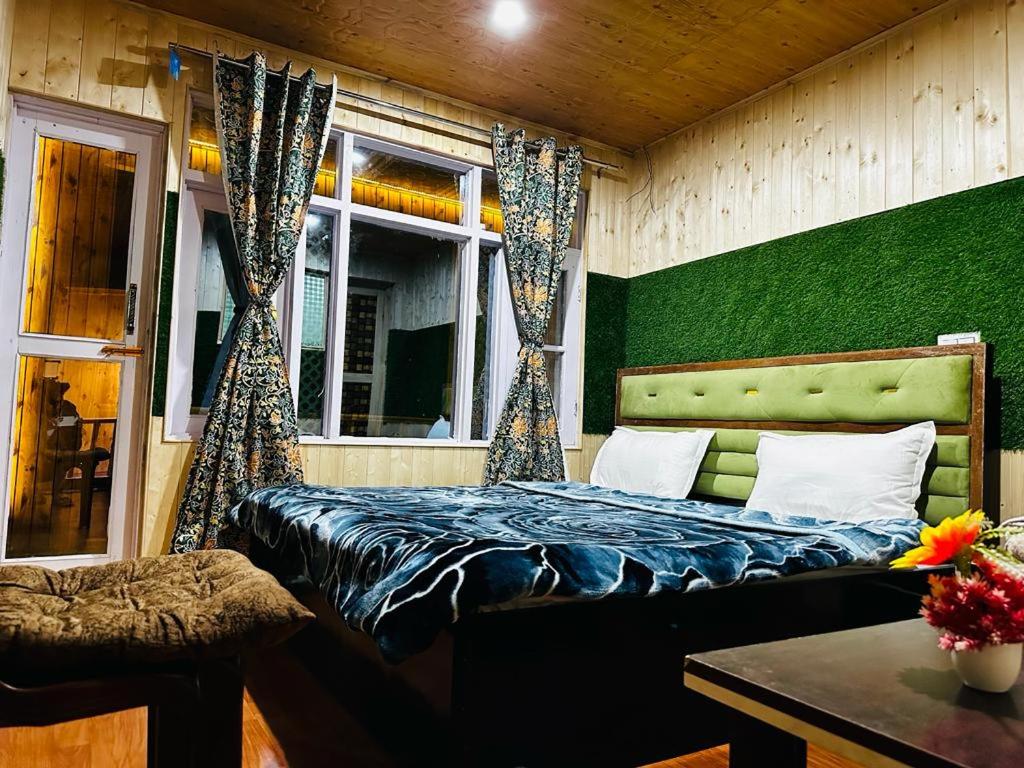 Kanzalwan的住宿－D’SHIEKHS RESORT GUREZ，一间卧室设有一张床和绿色的墙壁