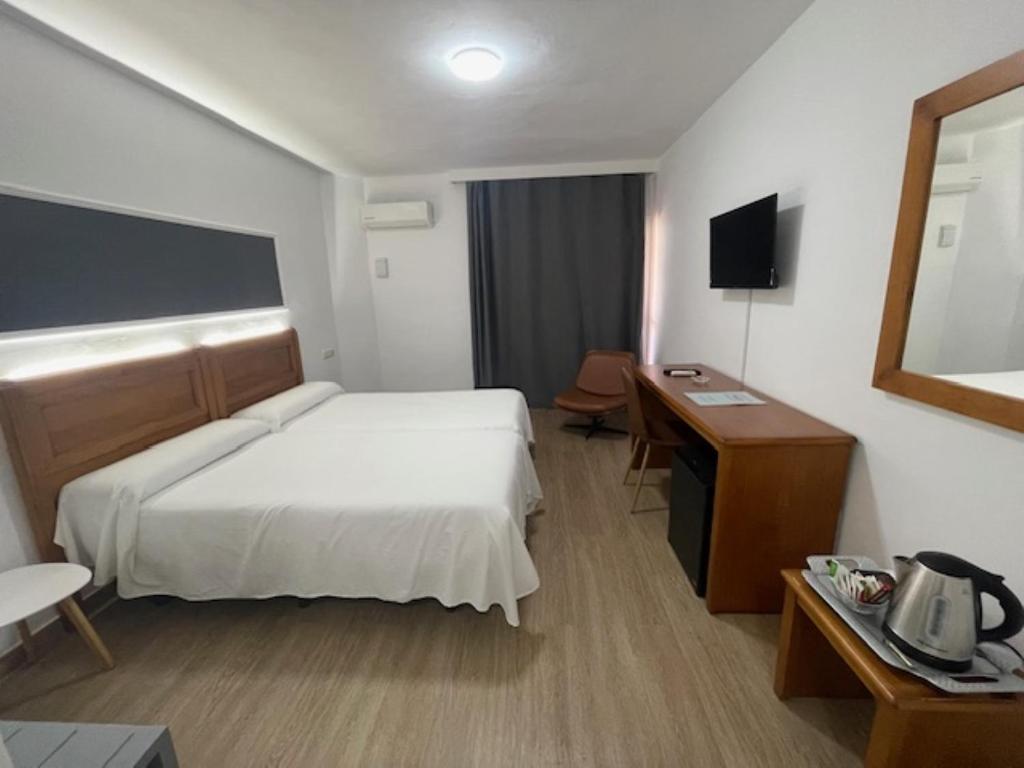 um quarto de hotel com uma cama e uma secretária em Hotel Anfora em Melilha