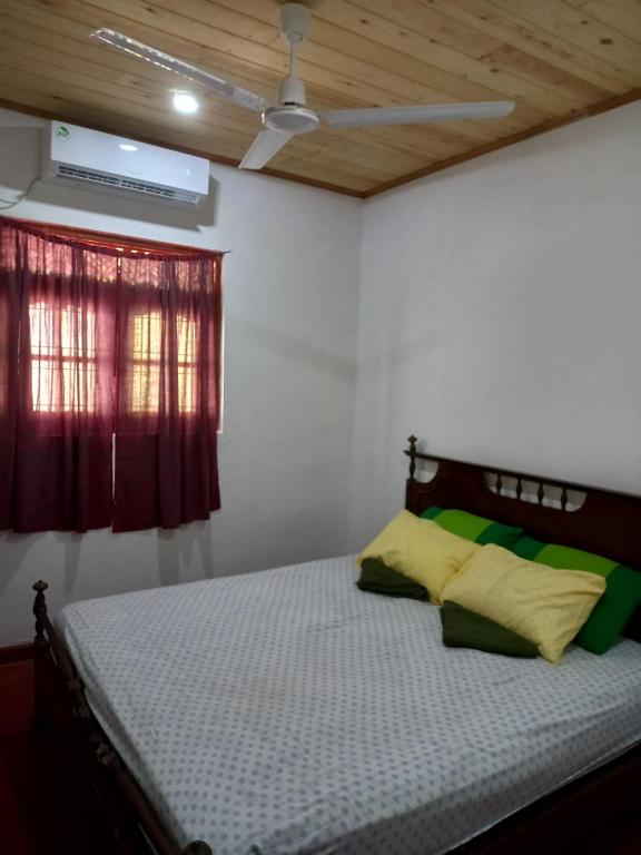 米瑞莎Indika Family Villa的红色窗户的房间里一张床位