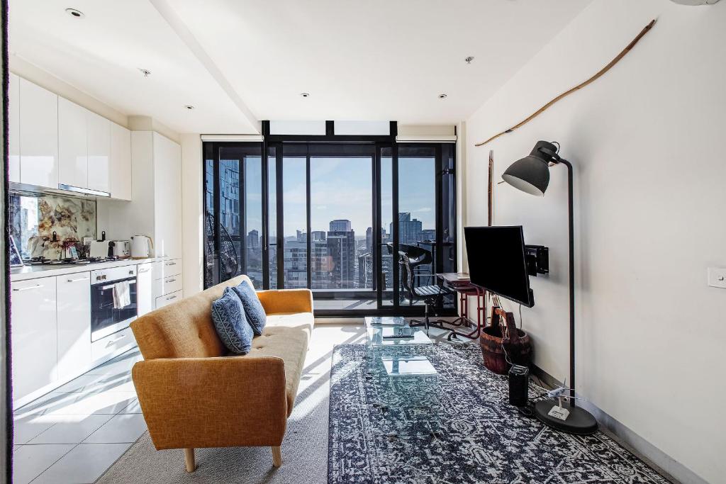 a living room with a couch and a tv at Skyline Allure - Urban Wellness meets City Living in Melbourne