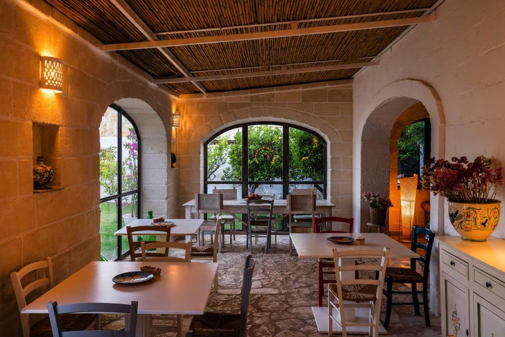 a restaurant with tables and chairs and windows at Masseria della Piana in Villanova di Ostuni