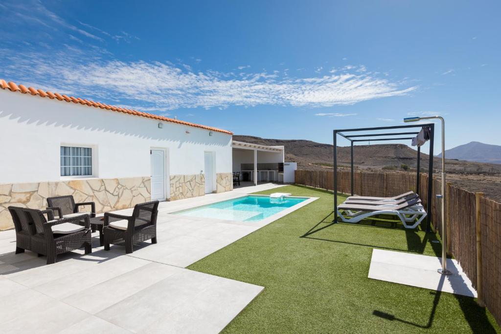a patio with a swing and a swimming pool at Villa Gregorio in Cardón