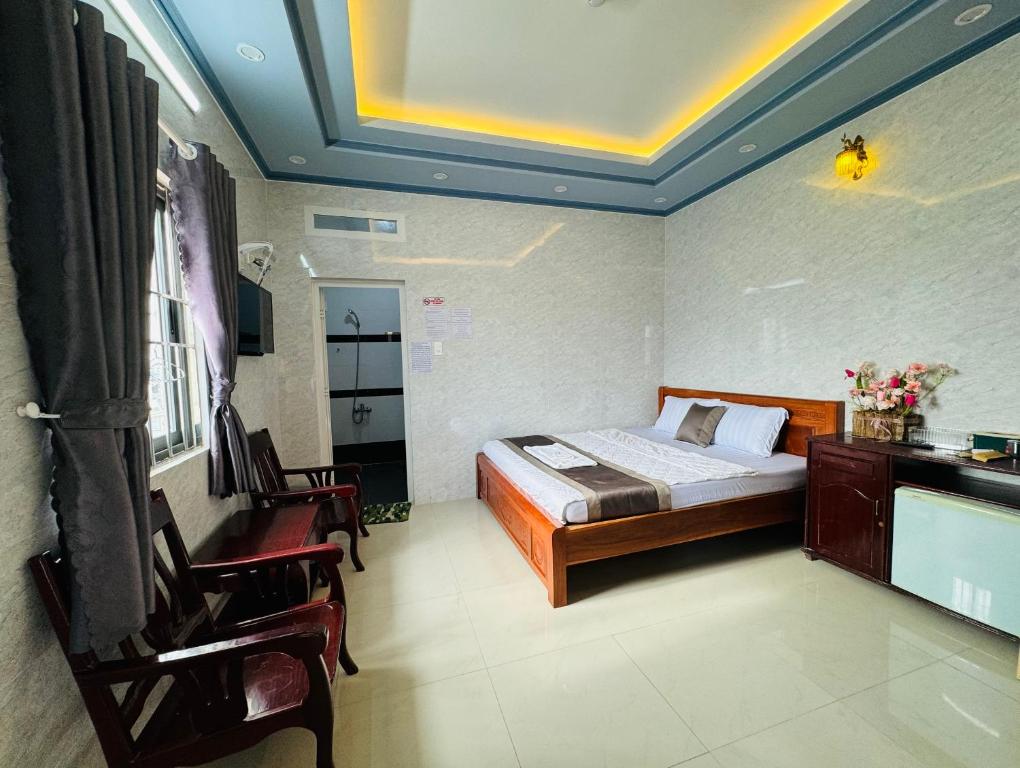 芹苴的住宿－PHÚ PHƯƠNG NAM HOTEL，卧室配有一张床和一张桌子及椅子