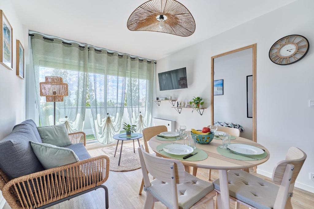 une salle à manger et un salon avec une table et des chaises dans l'établissement Au bon repos - Appt proche de la mer, à Cabourg