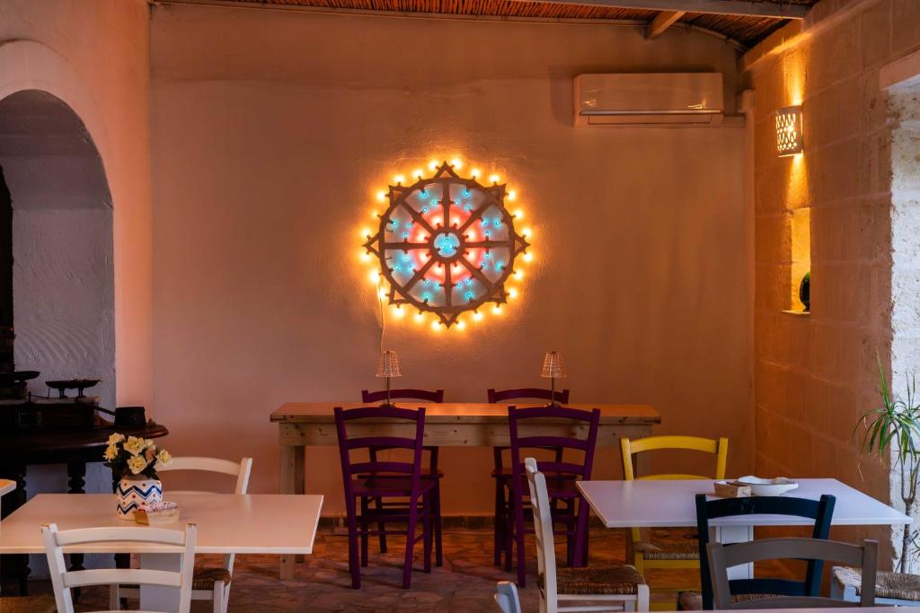 a dining room with tables and chairs and a large window at Masseria della Piana in Villanova di Ostuni
