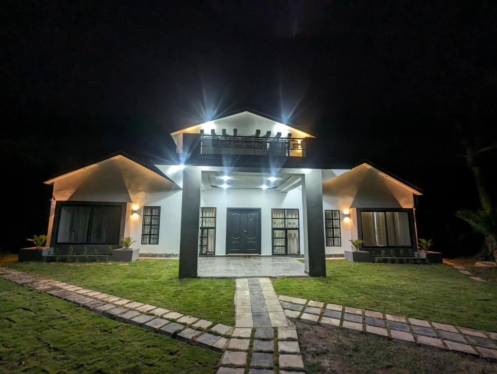 una casa con luces encendidas por la noche en Adventure Techie Resort, en Islamabad