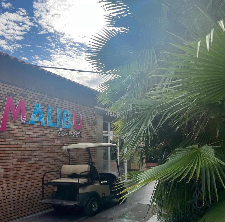 une voiturette de golf garée devant un bâtiment dans l'établissement T2 Hawaï - Malibu Village, à Canet