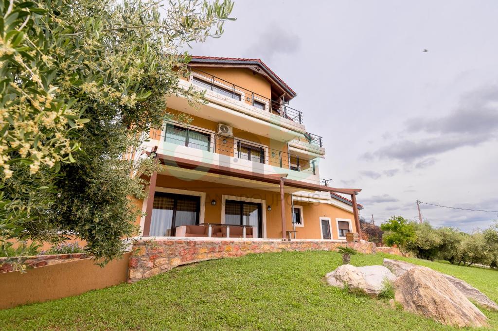 a large yellow house on a grassy field at ''Villa Elia'' in Dhíkella