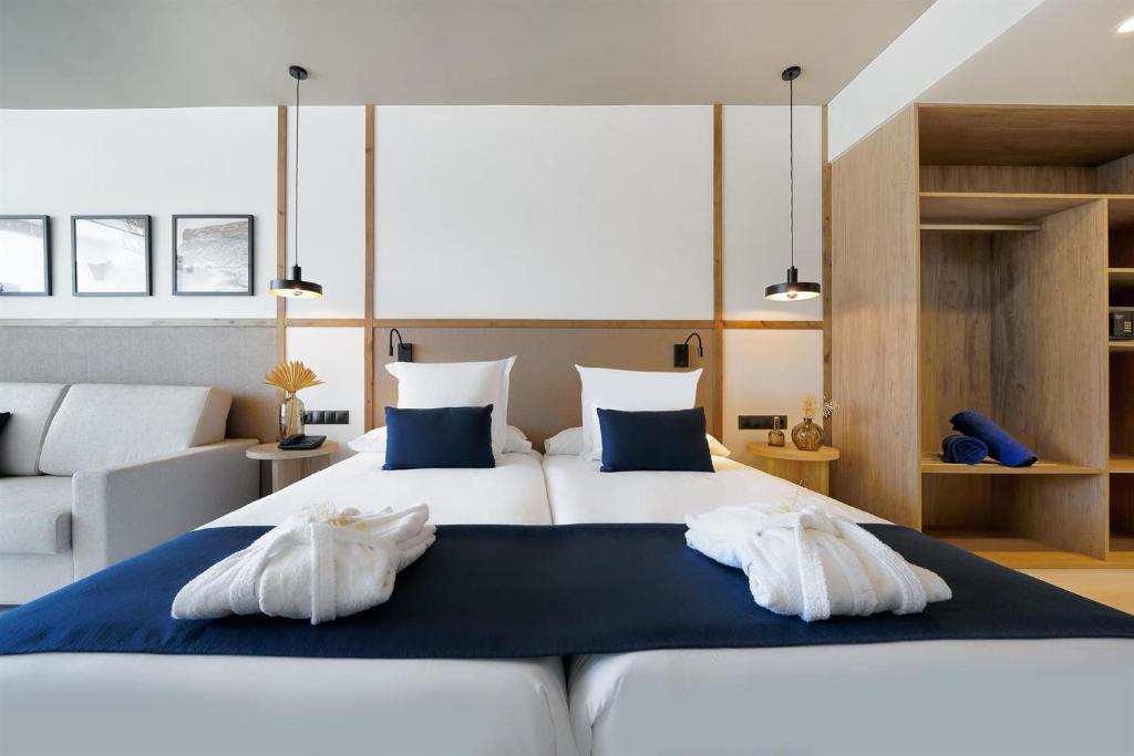 1 dormitorio con 1 cama grande y 2 almohadas blancas en H10 Costa Mogán, en Playa del Cura