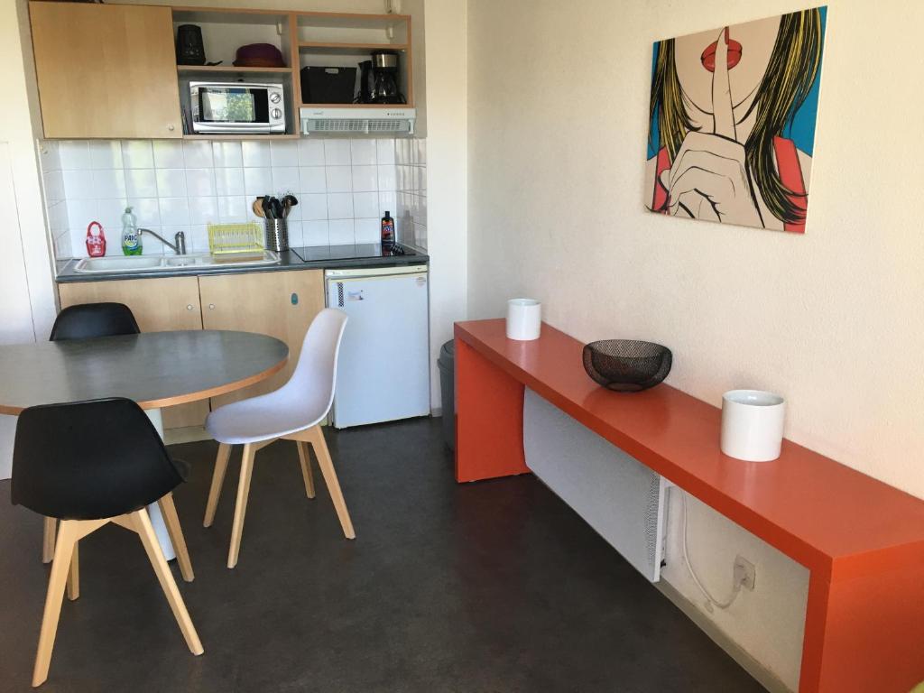 une cuisine avec une table, des chaises, une table et une table. dans l'établissement APPARTEMENT IDEAL FAMILLE, à La Rochelle