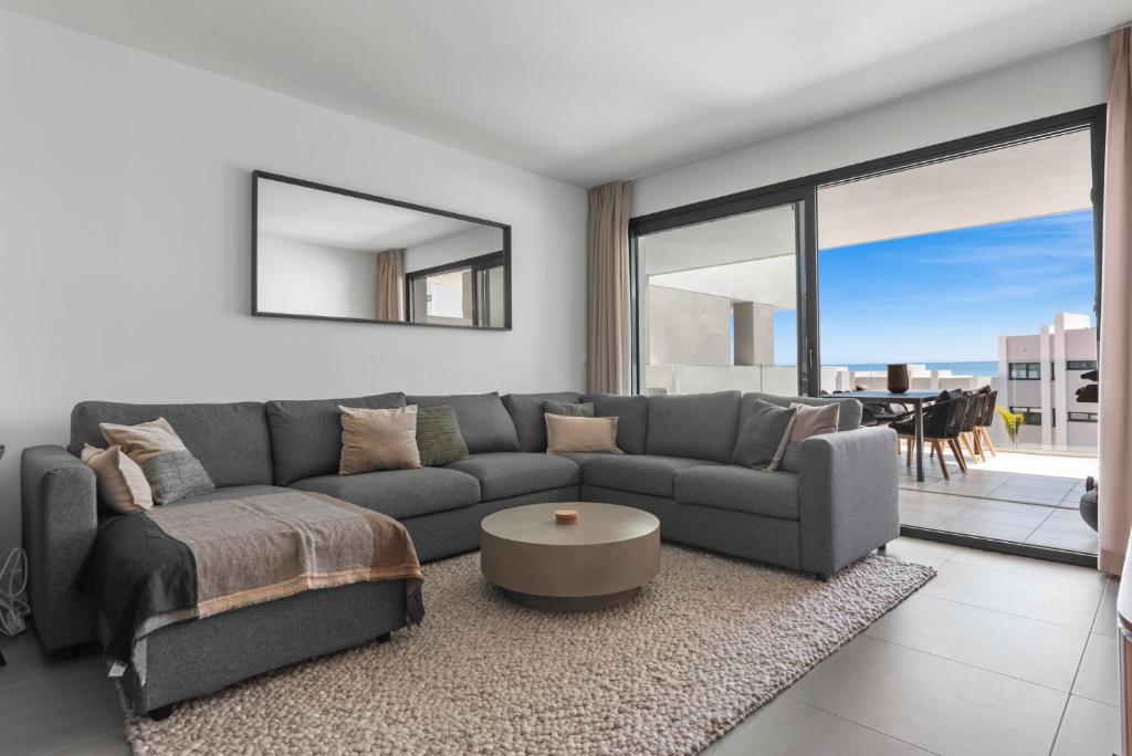 ein Wohnzimmer mit Sofa und Tisch in der Unterkunft Luxury Seaview Resort Apartment in Manilva