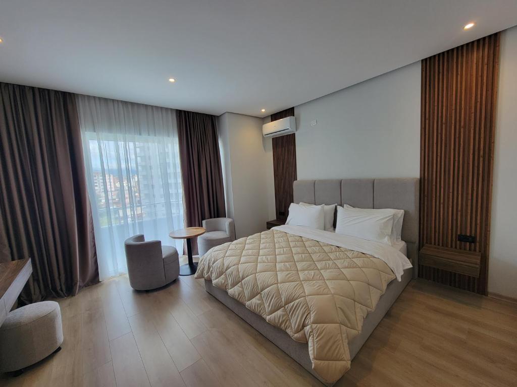 a bedroom with a large bed and a large window at Hotel Enkelana in Pogradec
