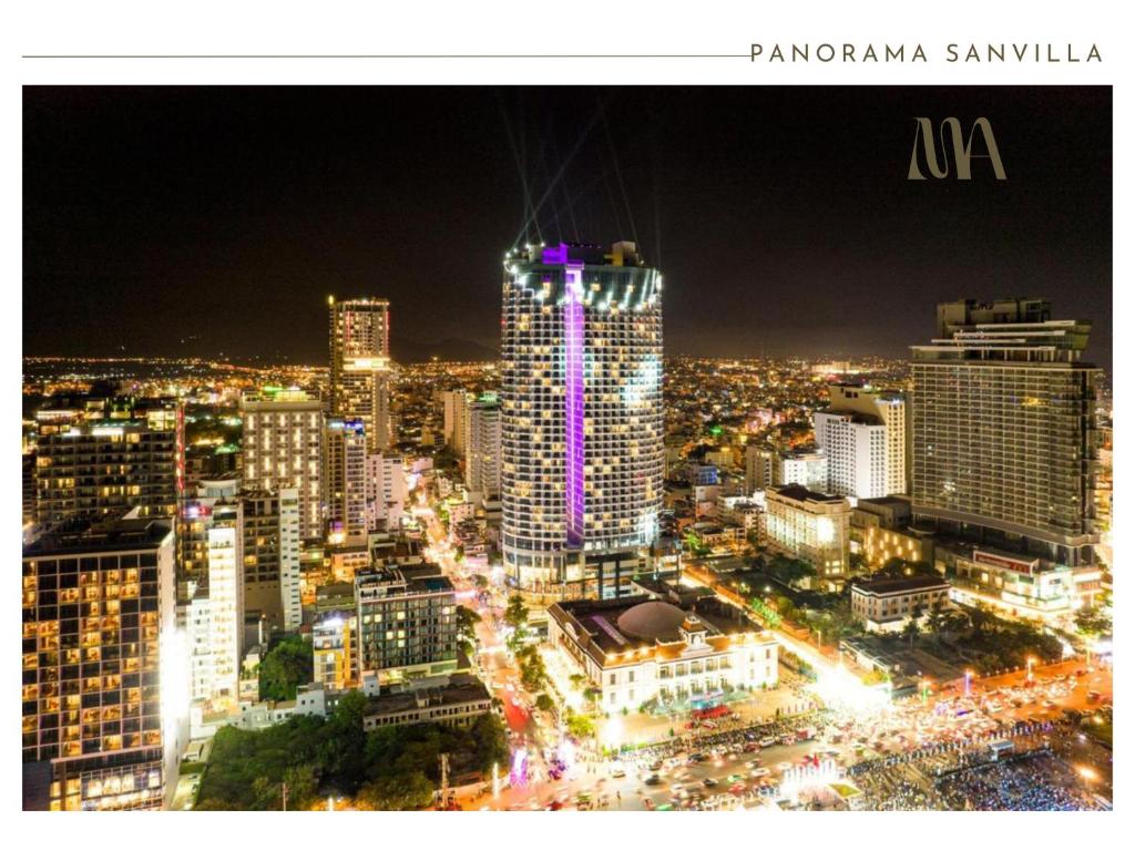 a night view of a city with a tall building at Panorama Nha Trang SanVilla in Nha Trang