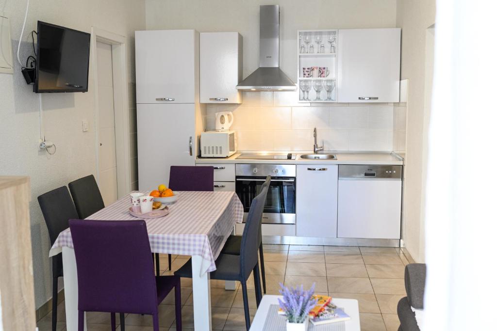 a kitchen and dining room with a table and chairs at Apartments Coric in Trogir