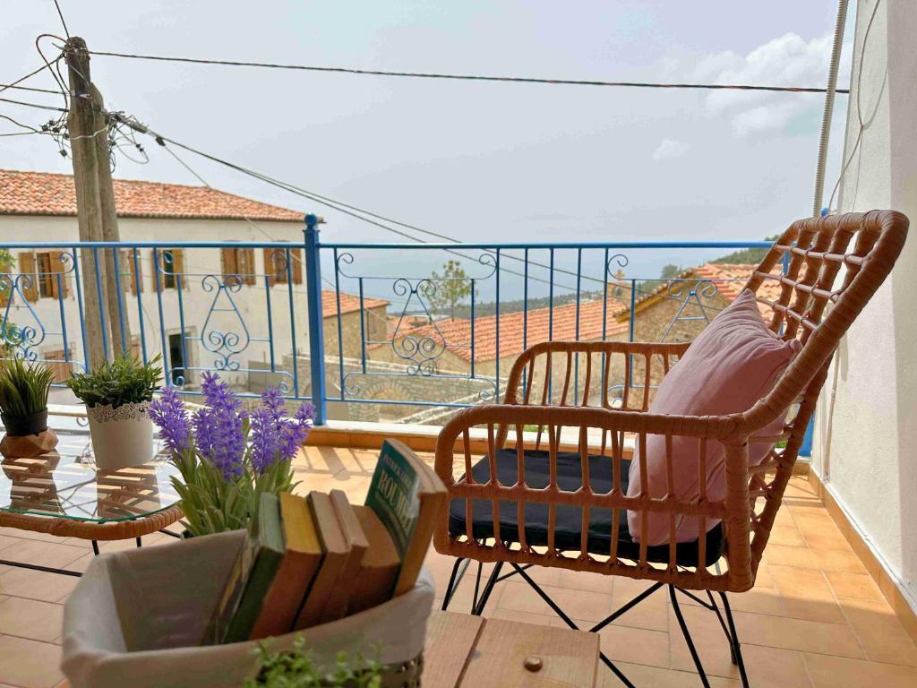 a balcony with a chair and a table with flowers at Kalderimi View House in Dhërmi