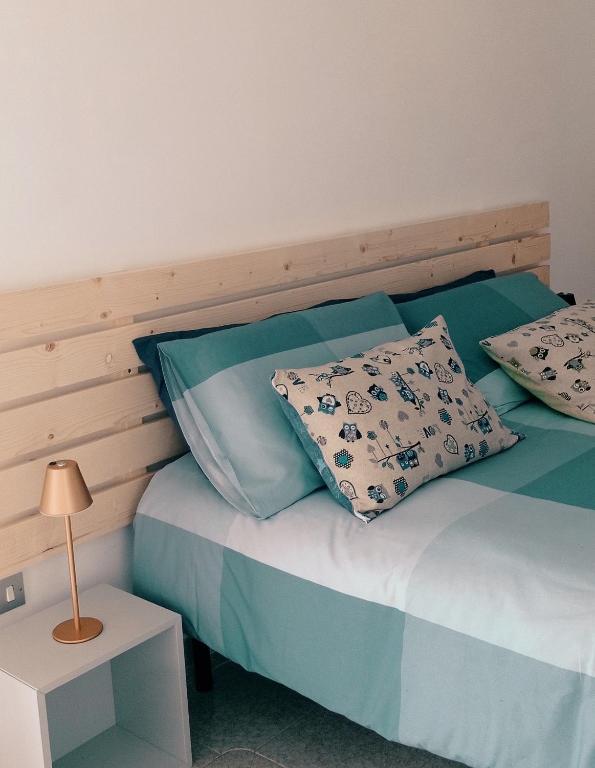 a bed with blue and white sheets and pillows at B&B Casa Giardino Ferrazzano in Ferrazzano