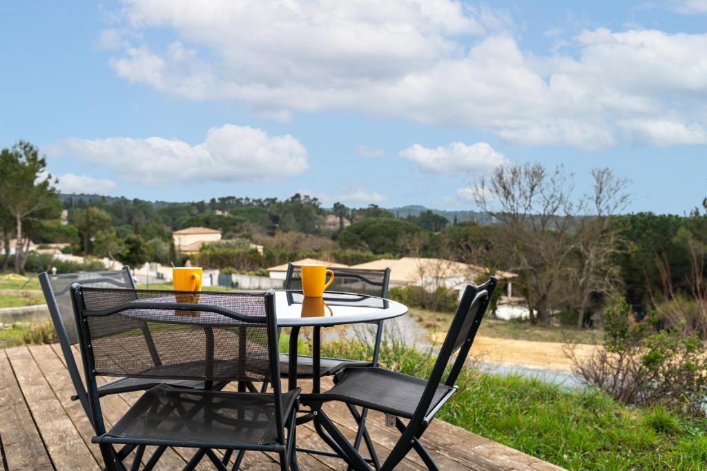 - une table avec deux chaises et deux tasses dans l'établissement Le Soleil du Lac/Terrasse/Parking/Clim, à Carcassonne