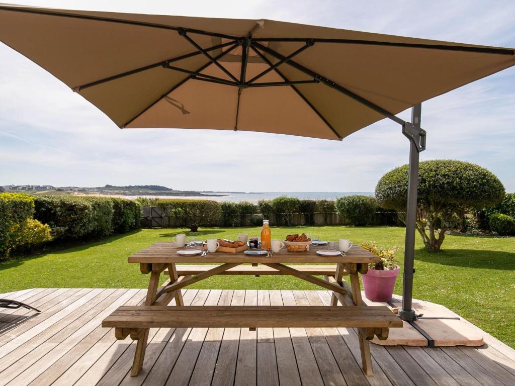 stół piknikowy z parasolem na pokładzie w obiekcie Holiday Home La Vigie - LPU104 by Interhome w mieście Clohars-Carnoët