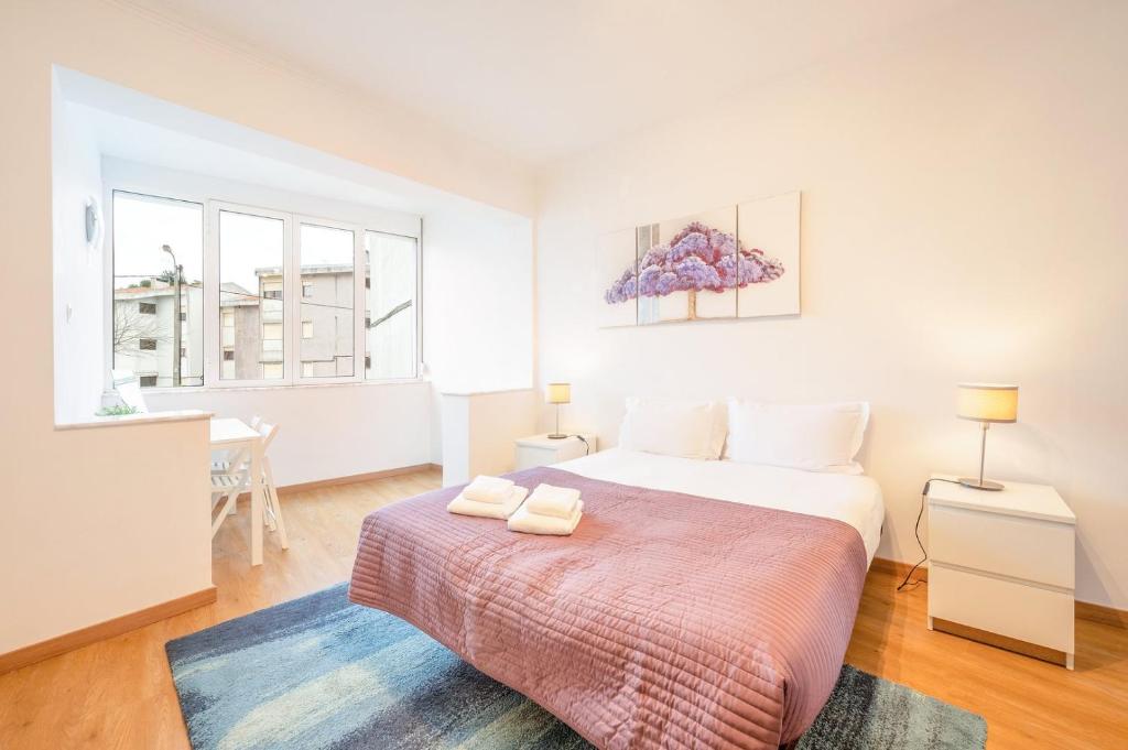 a bedroom with a bed with two towels on it at GuestReady - Spacious Apt near Cascais City Centre in Alvide