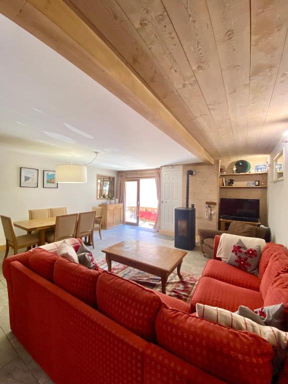 un salon avec un canapé rouge et une table dans l'établissement Appartement cosy, spacieux & moderne - 95m2, à Lanslebourg-Mont-Cenis