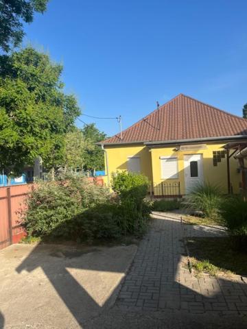żółty dom z ceglanym chodnikiem przed nim w obiekcie Dyta2 apartman w Hajduszoboszlo
