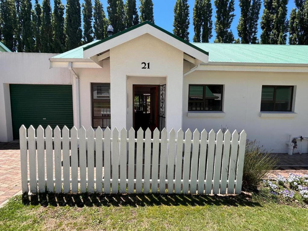 una casa blanca con una valla blanca en Clarens The Paddocks 21, en Clarens