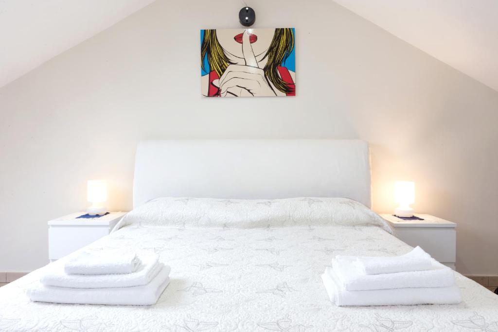 - une chambre avec un lit blanc et 2 lampes dans l'établissement A Pochi Passi, à Venaria Reale