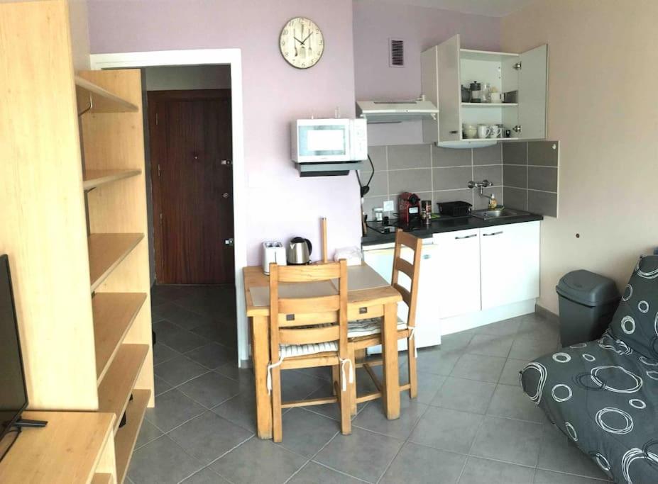 une petite cuisine et salle à manger avec une table et des chaises dans l'établissement Studio BAOBAB, à Chambéry