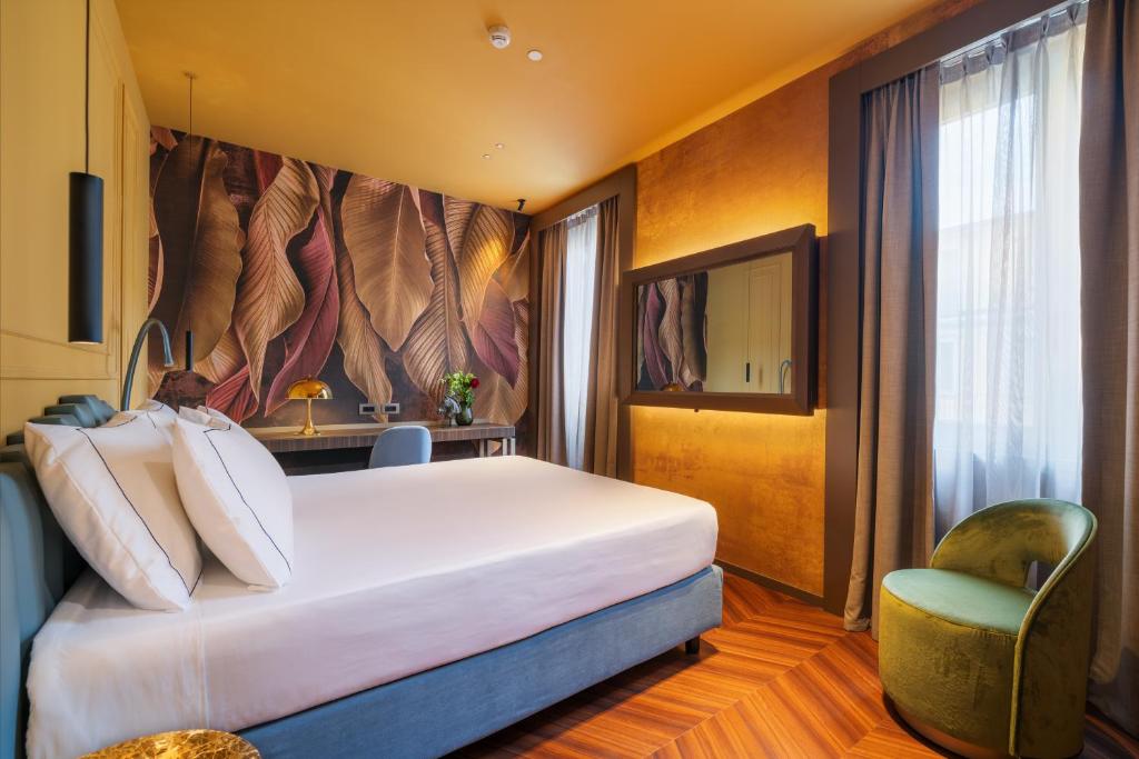 a hotel room with a large bed and a chair at WorldHotel Casati 18 in Milan