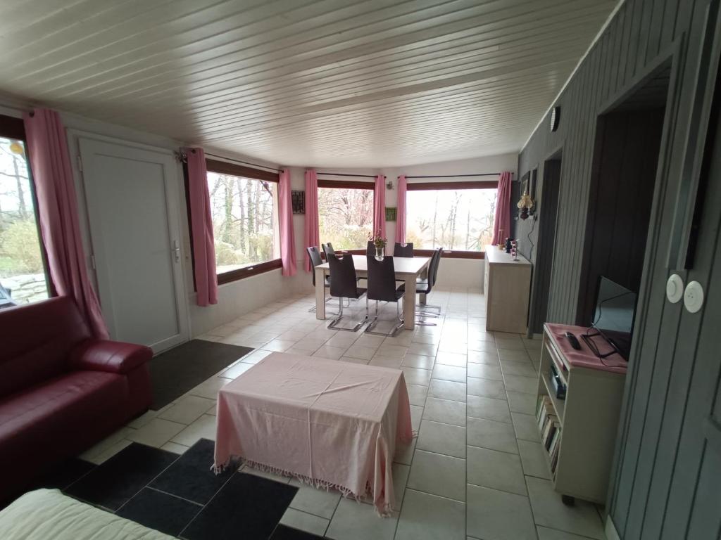 a living room with a couch and a table at La véranda au domaine de Tara in LʼHôpital-du-Grosbois