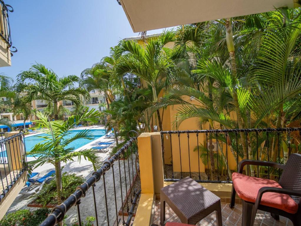 a balcony with a view of a pool and palm trees at Garden Condos 10, 2br Apt In Sosua Strip in Sosúa