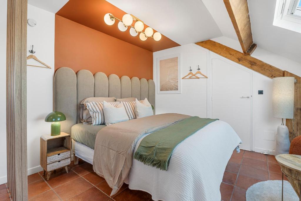 une chambre avec un grand lit aux murs orange dans l'établissement Nice Renting - GOUNOD - Haven Retreat Under Roof Air-Conditioned, à Nice