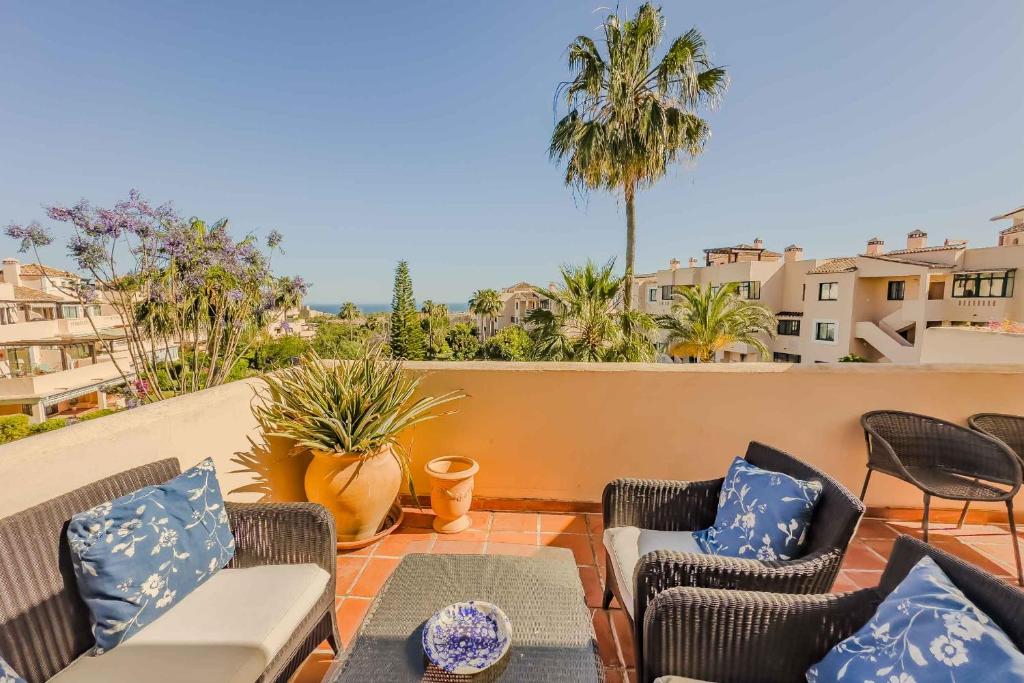 patio z krzesłami i stołem na balkonie w obiekcie 75-Apartment with Views in Elviria, Marbella w Marbelli
