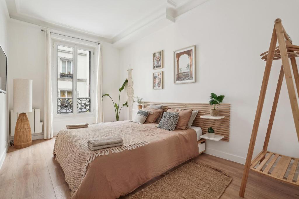 une chambre avec un grand lit dans une pièce blanche dans l'établissement Villa Arc de Triomphe, à Paris