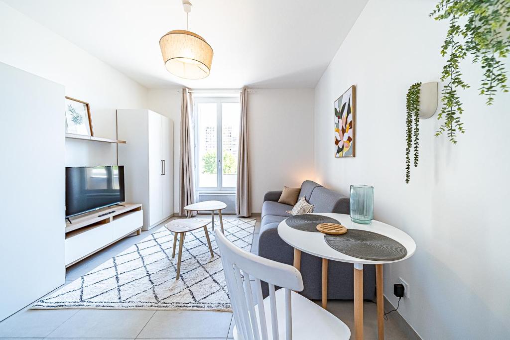 a living room with a couch and a table at Le Petit Clément - Charmant et Cosy in Villeurbanne