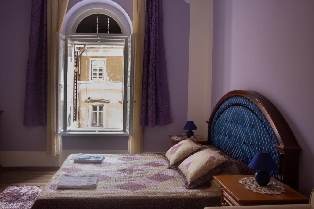 a bedroom with a bed and a window at Rooms Cristal Roche in Rijeka