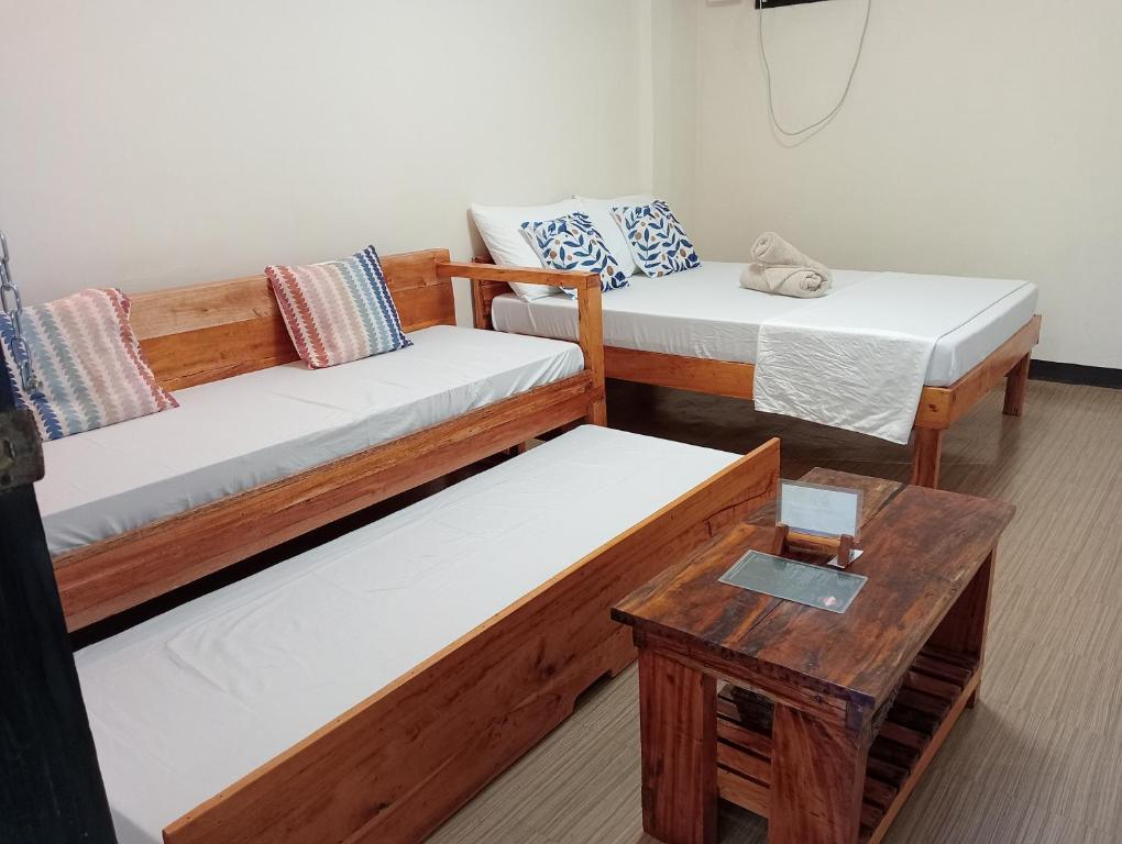 a room with two beds and a table at Solana Siargao in Catagnan