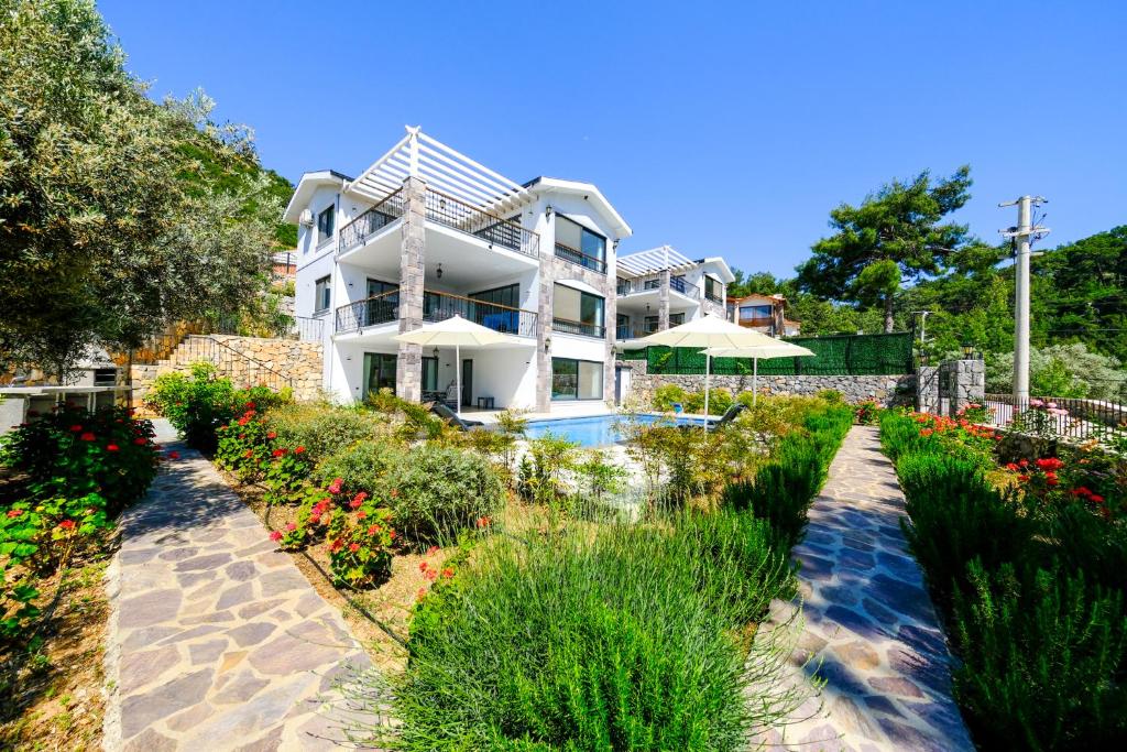 une maison avec un jardin et une piscine dans l'établissement Olive Hills Villa - Family-Friendly Luxury Villa Uzumlu Fethiye by Sunworld Villas, à Fethiye