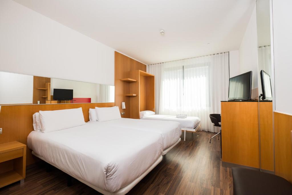 a hotel room with two beds and a television at Hotel SB Icaria in Barcelona