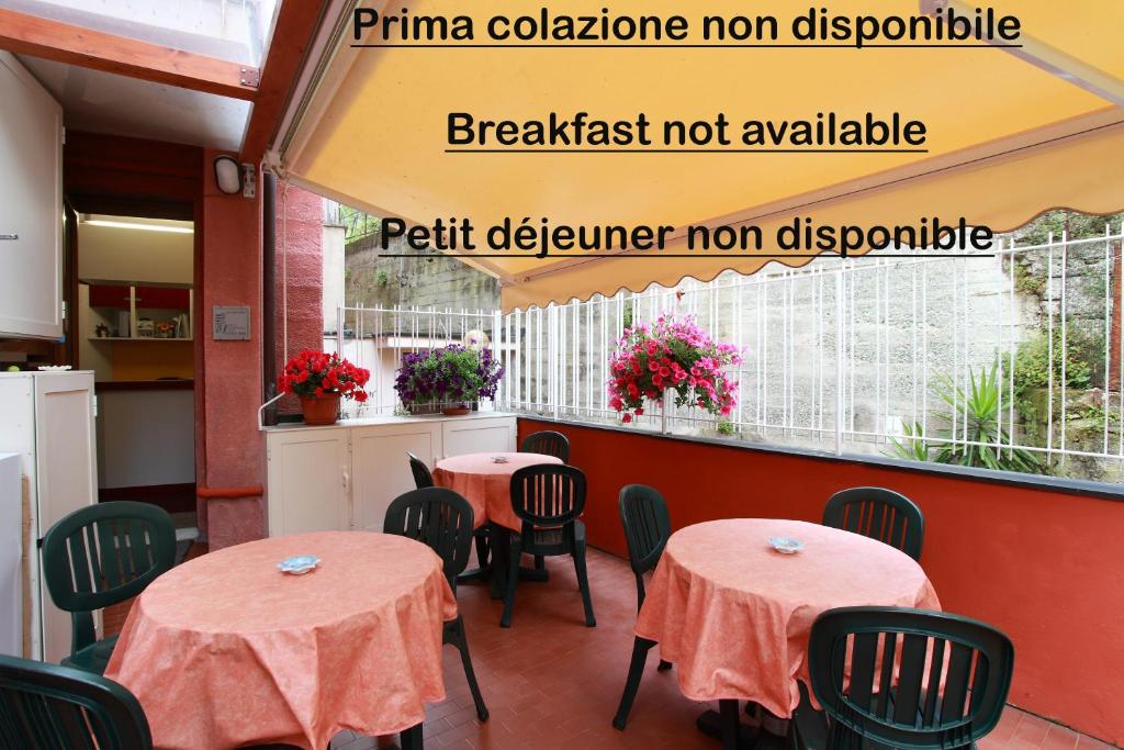a restaurant with two tables and a balcony with flowers at Albergo Al Carugio in Monterosso al Mare