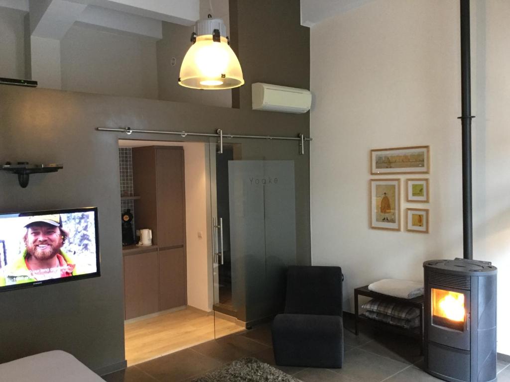 a living room with a tv on a wall at B&B Wellness Yoake in Ypres