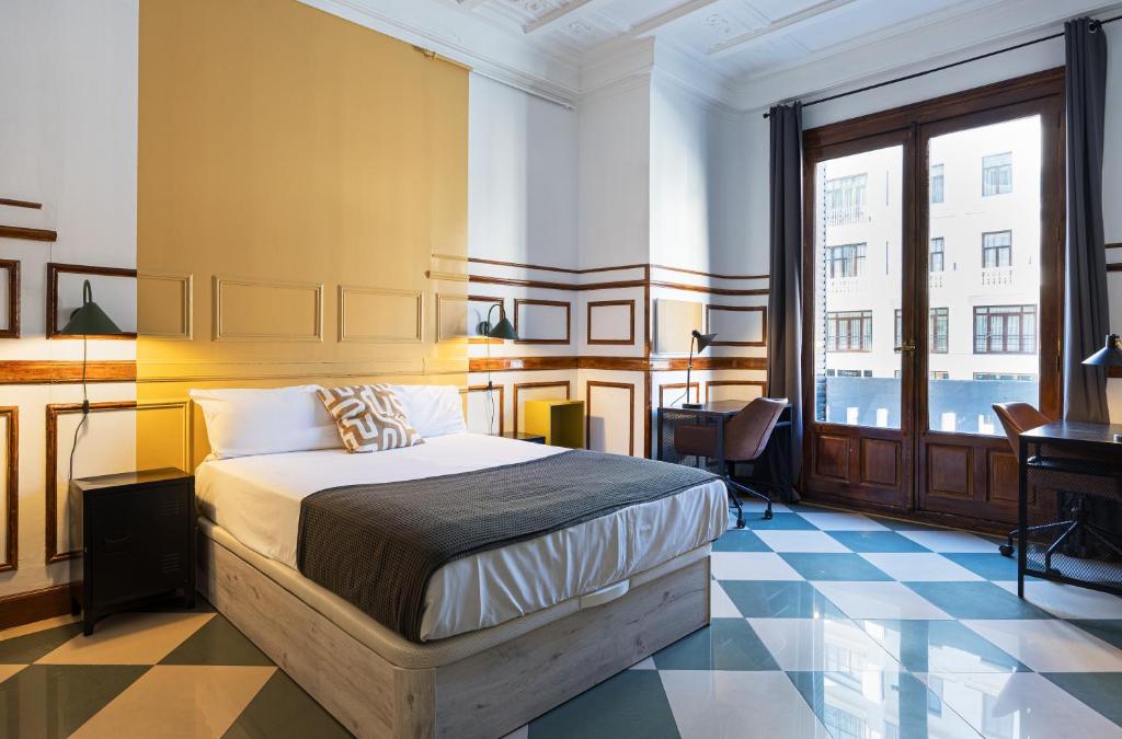 un dormitorio con una cama y un escritorio en Live it Madrid Gran Vía, en Madrid