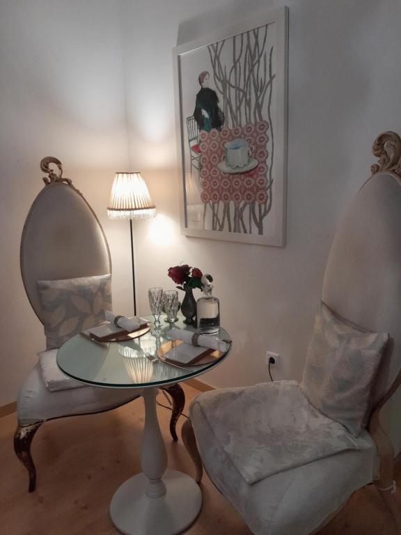 mesa y 2 sillas en una habitación con lámpara en Espaco Edla, en Sintra