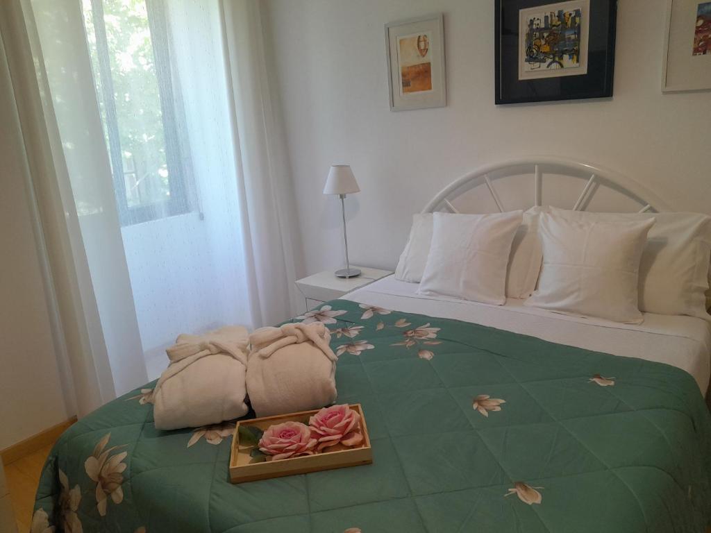 ein Schlafzimmer mit einem Bett und einem Tablett mit Rosen darauf in der Unterkunft Espaco Edla in Sintra