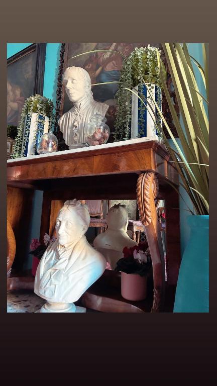 uma estante de madeira com estátuas e plantas em Art action room 