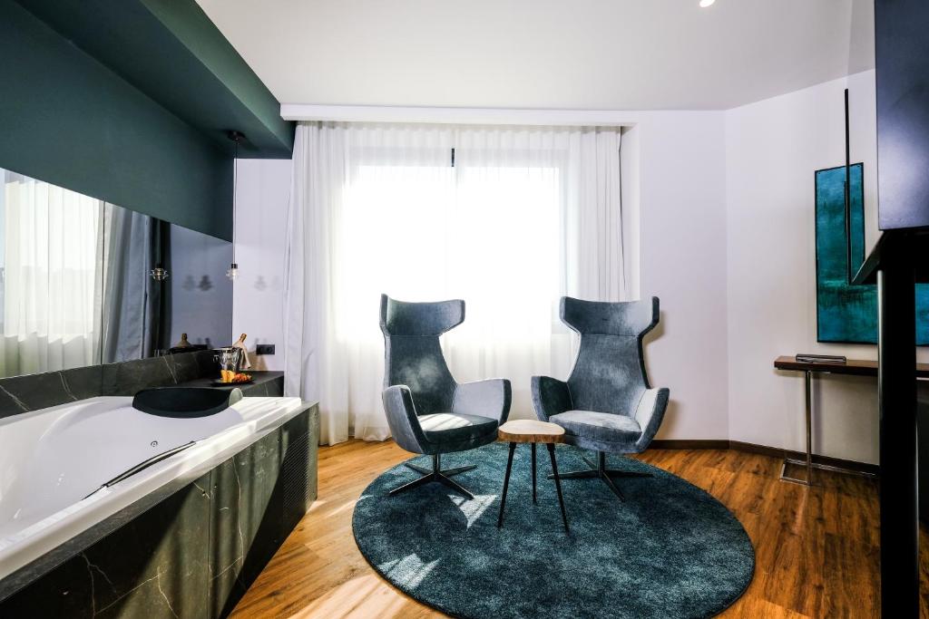 a living room with two chairs and a tub at Hotel SB Icaria in Barcelona