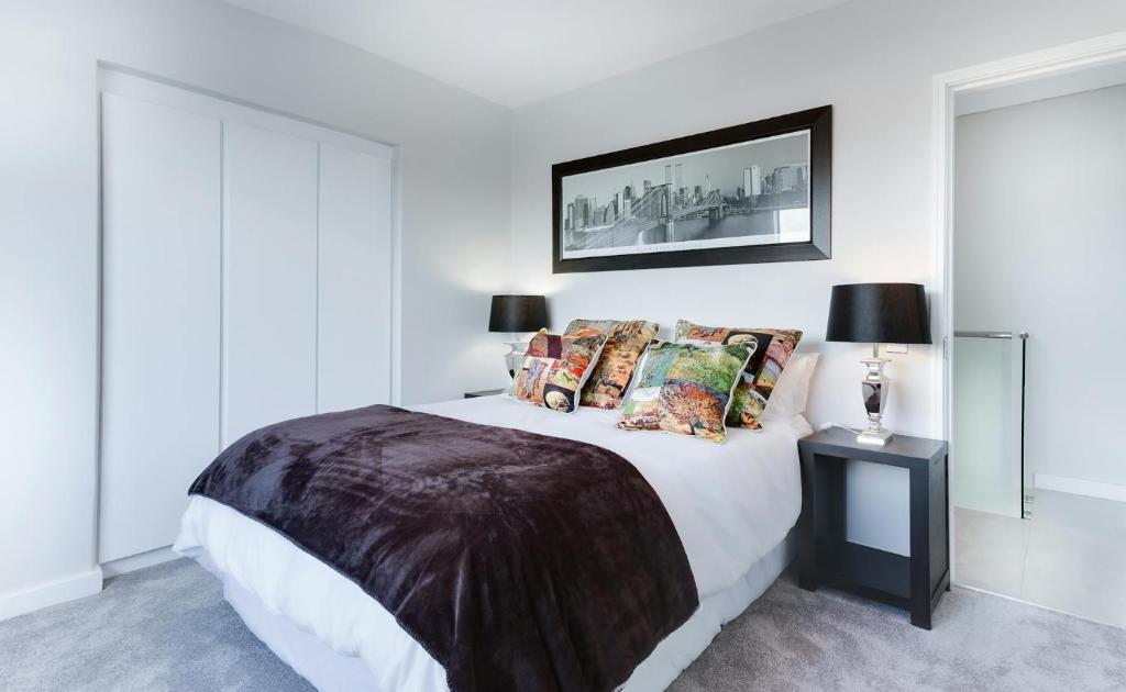 een slaapkamer met een groot wit bed met kussens bij Heritage care hotel in Split